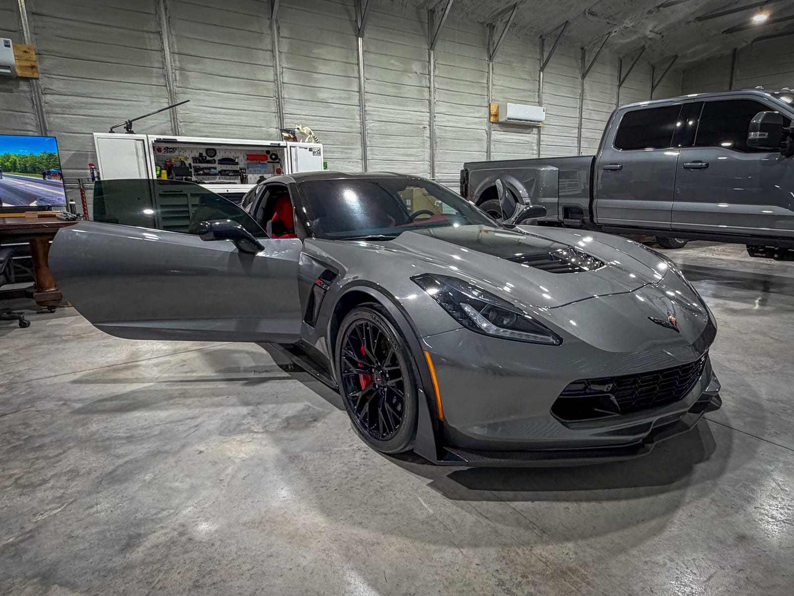 Gray Chevrolet Corvette Z06 with a red interior and the door open inside the shop