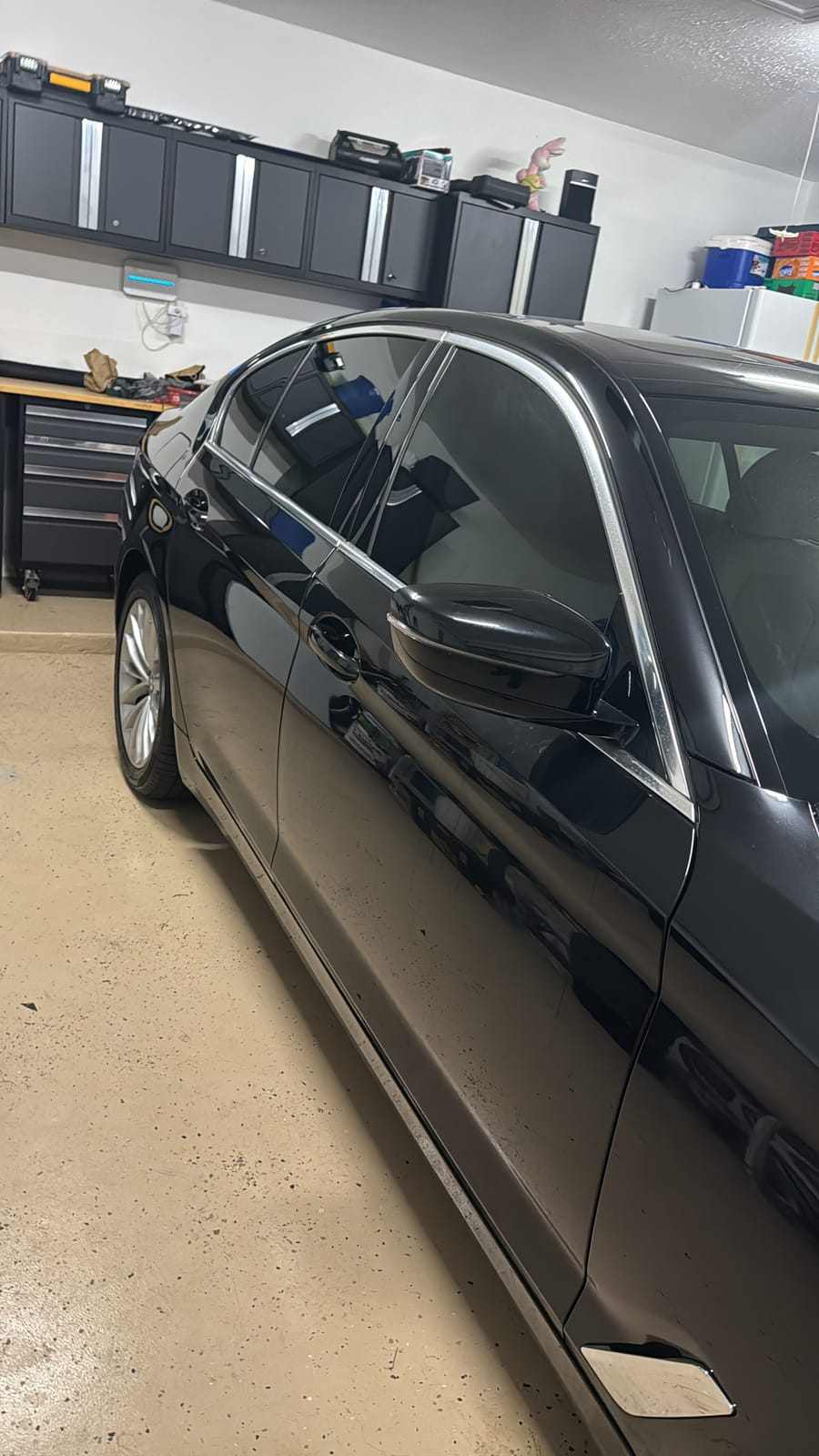 Black BMW 5 Series sedan showing clean dark tint on the door glass in a garage