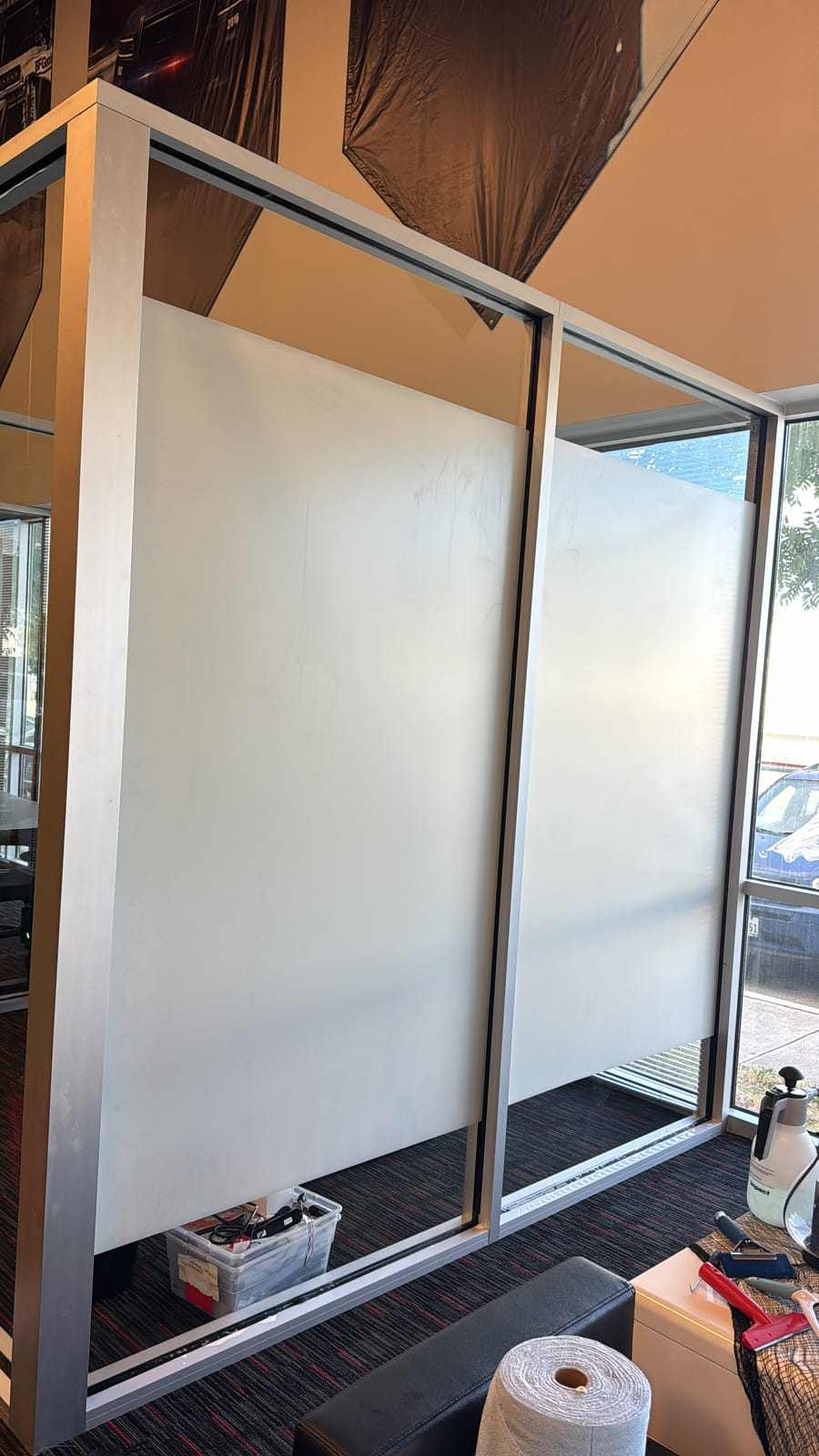 Glass office partition walls finished with frosted privacy film for a private meeting space