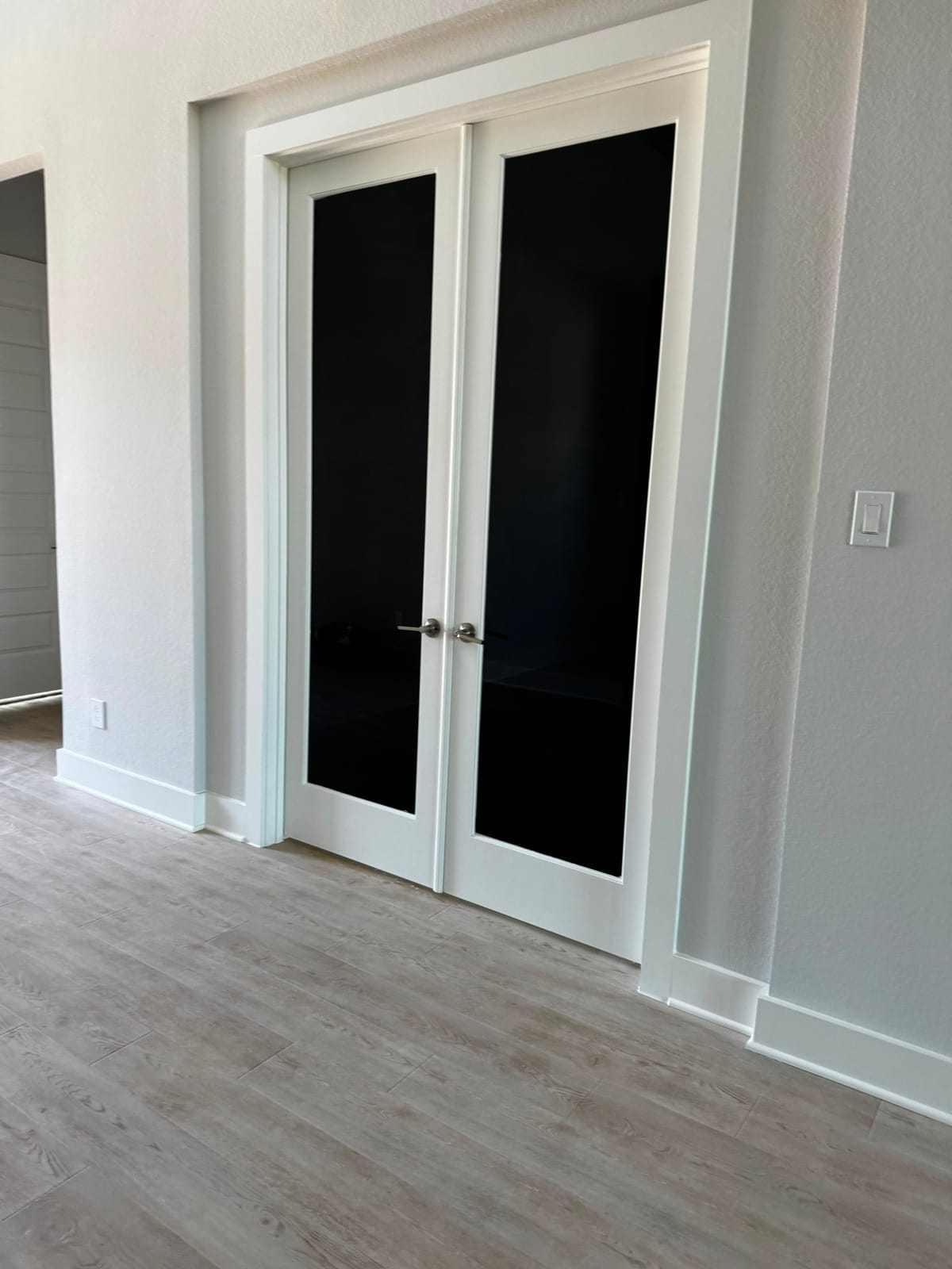 Interior French doors in a home fitted with dark privacy film on both glass panels