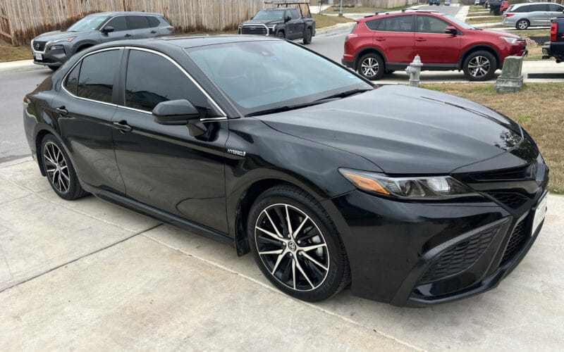 Black Toyota Camry Hybrid parked in a residential driveway after mobile auto care service